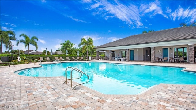 community pool with a patio area and fence