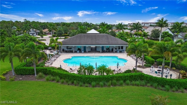 community pool with a patio, a yard, and fence