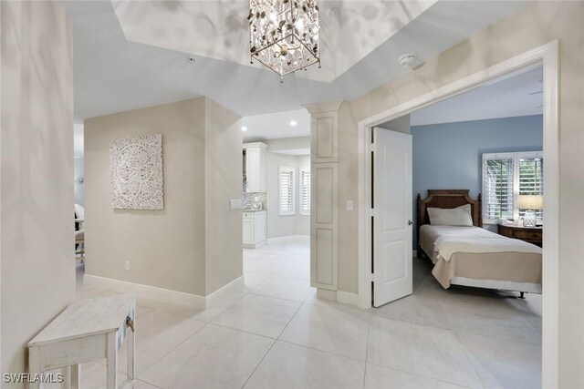 corridor with plenty of natural light, recessed lighting, baseboards, and a chandelier