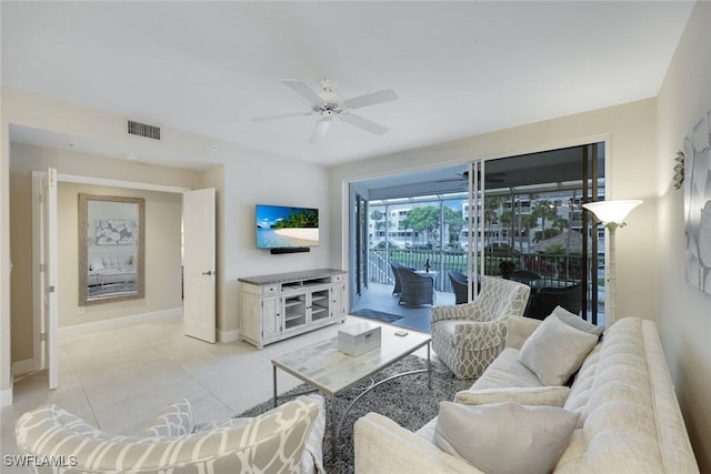 living area featuring light tile patterned floors, visible vents, baseboards, and ceiling fan