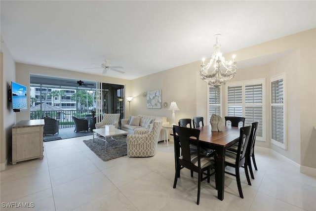 dining room with light tile patterned flooring, ceiling fan with notable chandelier, and baseboards