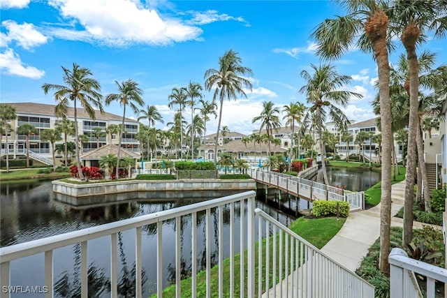 property view of water featuring a residential view, a boat dock, and fence