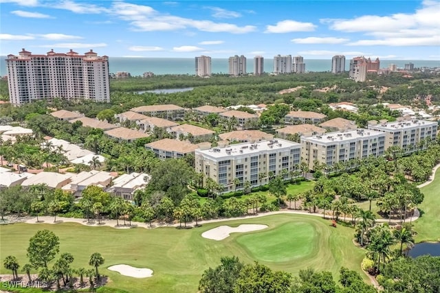 drone / aerial view with a city view, golf course view, and a water view