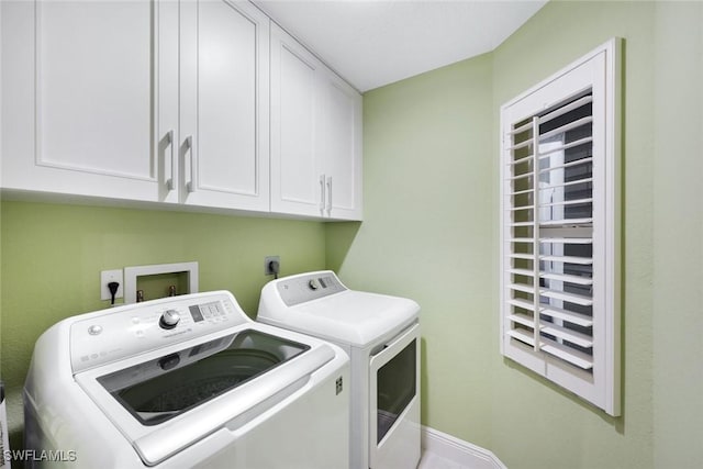 laundry room with baseboards, cabinet space, and washer and clothes dryer