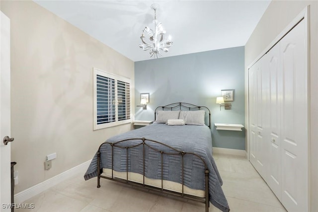 bedroom featuring a closet, a notable chandelier, tile patterned flooring, and baseboards