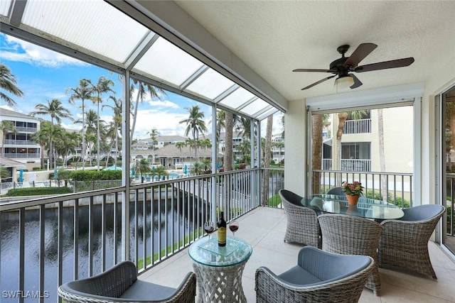 sunroom with a water view and a ceiling fan