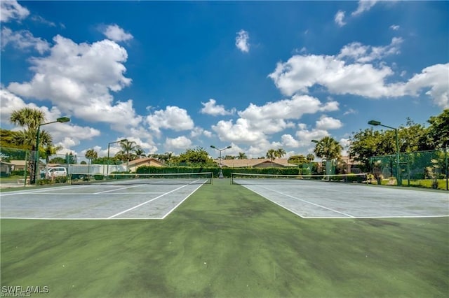 view of tennis court featuring fence