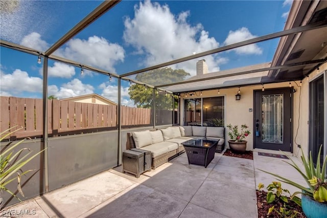 view of patio featuring a lanai, an outdoor living space, and a fenced backyard