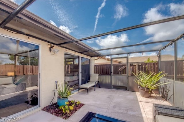 view of patio with a lanai and fence