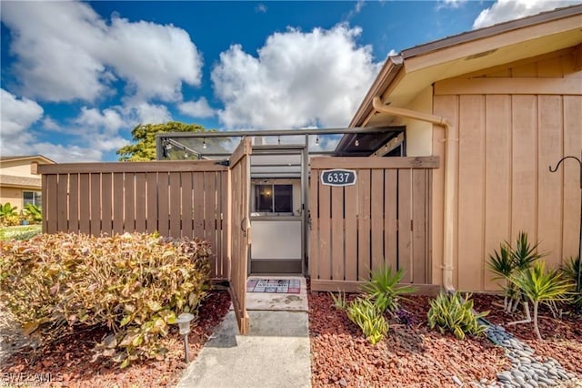 entrance to property with board and batten siding and fence