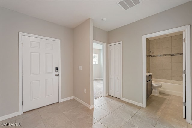 foyer featuring light tile patterned floors, visible vents, and baseboards