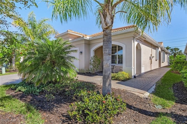 view of front of home featuring a tile roof and stucco siding