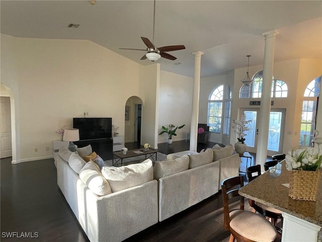 living room with arched walkways, high vaulted ceiling, dark wood-type flooring, and ceiling fan