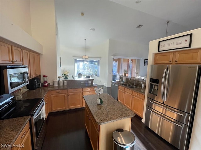 kitchen featuring visible vents, a sink, dark stone counters, appliances with stainless steel finishes, and a peninsula