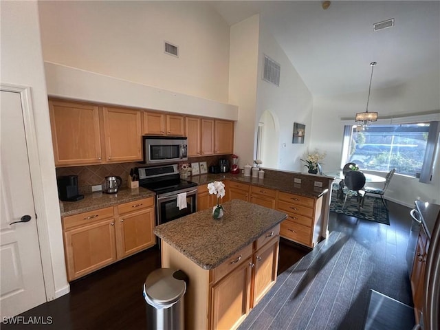 kitchen with visible vents, tasteful backsplash, dark wood finished floors, appliances with stainless steel finishes, and a peninsula