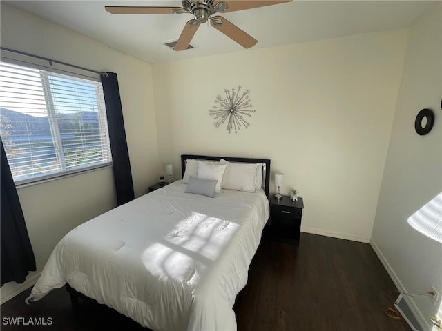 bedroom featuring ceiling fan, wood finished floors, visible vents, and baseboards