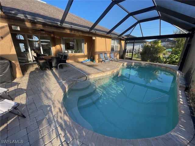 outdoor pool featuring outdoor dining space, glass enclosure, and a patio area