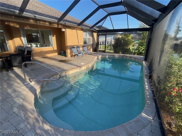 pool with glass enclosure and a patio