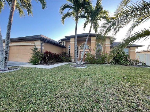 view of front of property with stucco siding, an attached garage, concrete driveway, and a front lawn