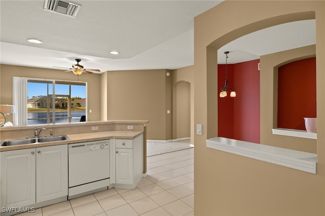 kitchen featuring visible vents, a sink, white cabinetry, arched walkways, and dishwasher