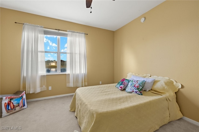 bedroom with vaulted ceiling, ceiling fan, baseboards, and carpet floors