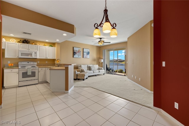 kitchen featuring open floor plan, white appliances, a peninsula, white cabinets, and light colored carpet