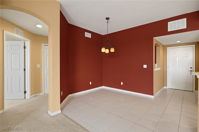 empty room with visible vents, arched walkways, and baseboards