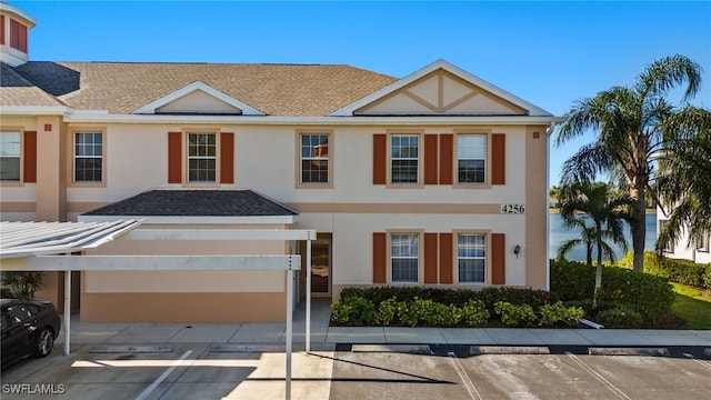 multi unit property featuring stucco siding, a shingled roof, and uncovered parking