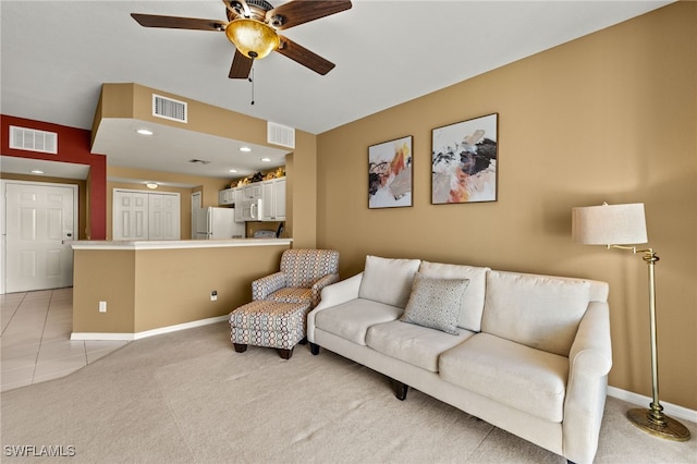 living area featuring visible vents, light colored carpet, and ceiling fan