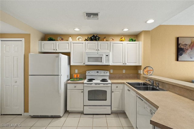 kitchen featuring visible vents, light countertops, a peninsula, white appliances, and a sink