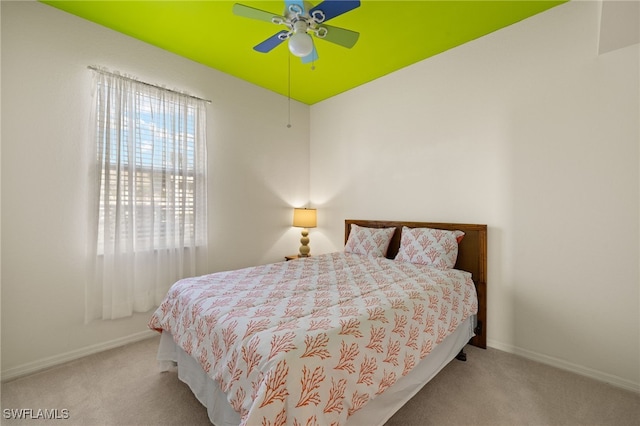 carpeted bedroom with baseboards, multiple windows, and ceiling fan