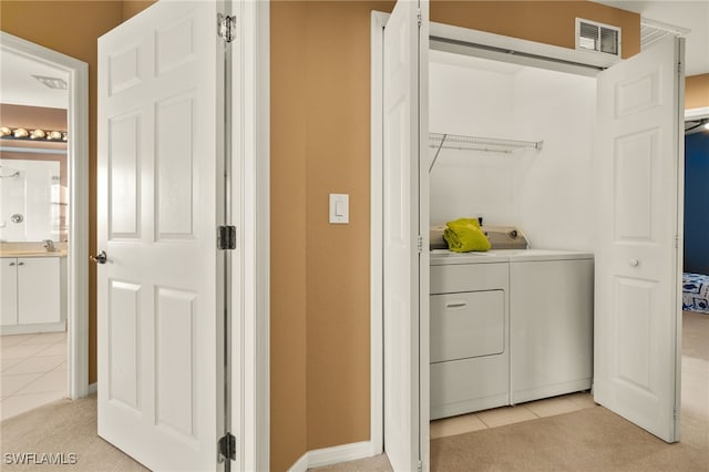 laundry room featuring light carpet, laundry area, light tile patterned flooring, and separate washer and dryer