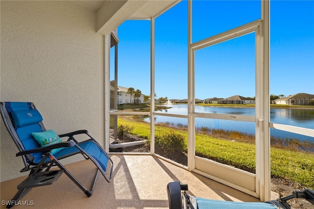 sunroom / solarium featuring a water view