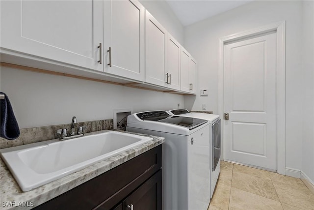 washroom featuring washer and clothes dryer, cabinet space, light tile patterned flooring, and a sink