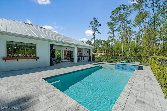 view of pool featuring a patio, ceiling fan, and a pool with connected hot tub