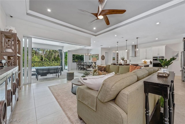 living room with recessed lighting, a raised ceiling, ceiling fan, and light tile patterned flooring