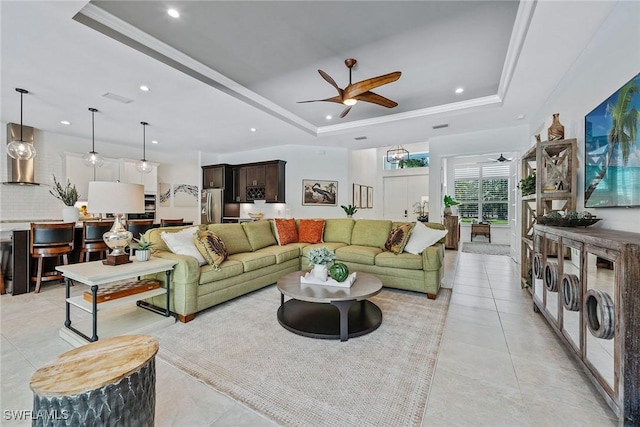 living room with recessed lighting, a tray ceiling, and a ceiling fan