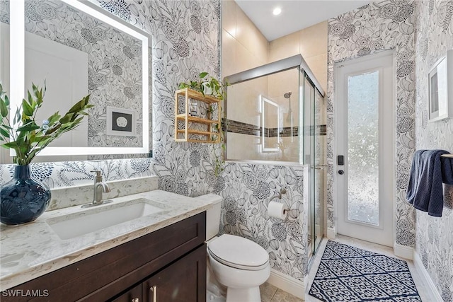 full bath with toilet, a stall shower, wallpapered walls, and vanity