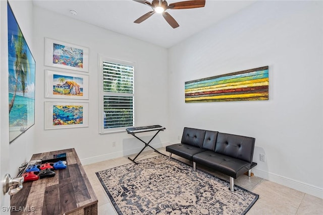 living area featuring tile patterned floors, baseboards, and ceiling fan