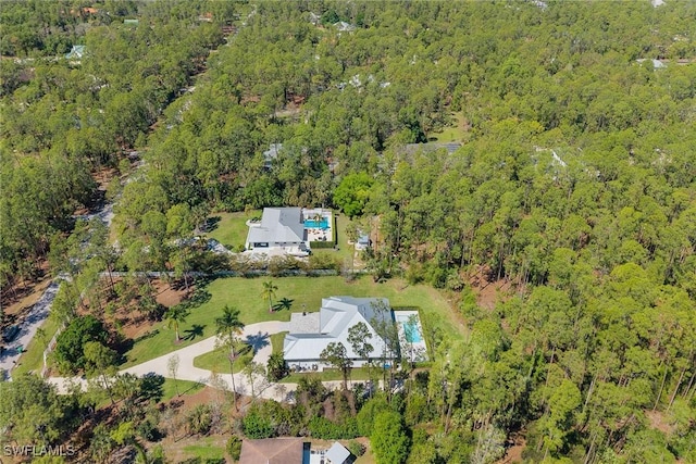 drone / aerial view with a wooded view