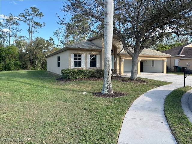 view of front of property featuring a front yard, concrete driveway, a tile roof, and stucco siding