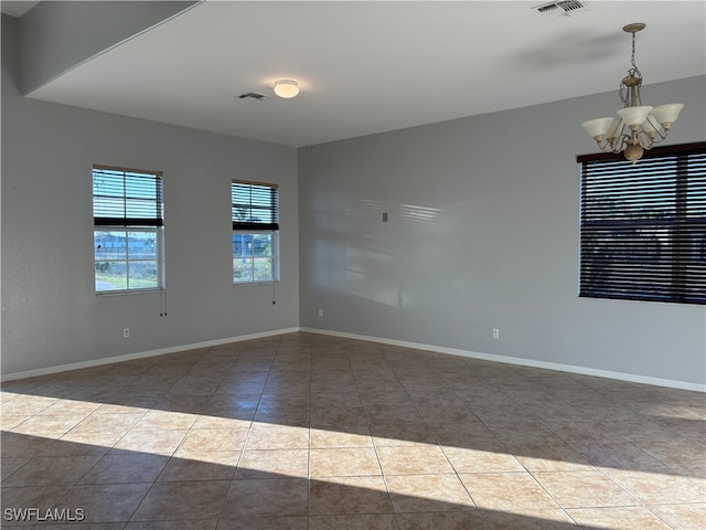 unfurnished room featuring visible vents, baseboards, a chandelier, and tile patterned flooring