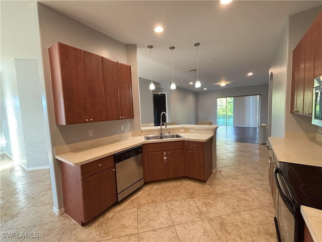 kitchen featuring light countertops, a peninsula, appliances with stainless steel finishes, and a sink