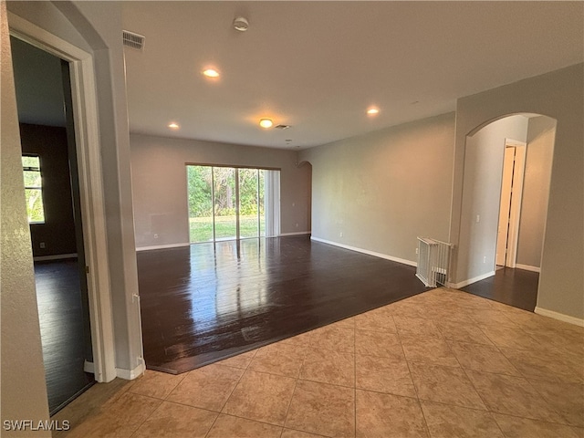 unfurnished room with visible vents, recessed lighting, arched walkways, tile patterned flooring, and baseboards