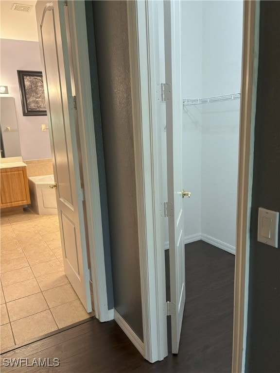 corridor featuring light wood-style flooring and baseboards