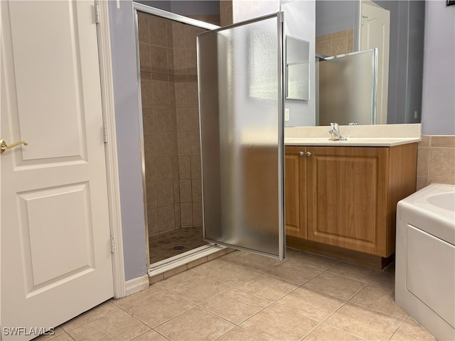 bathroom with tile patterned flooring, a stall shower, and vanity