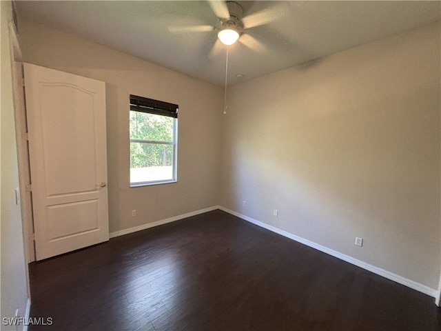 unfurnished room featuring baseboards, dark wood-type flooring, and ceiling fan