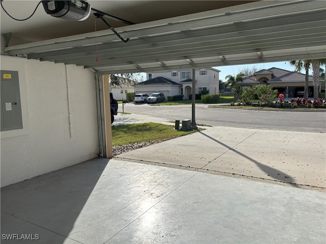 garage with electric panel, a residential view, and a garage door opener