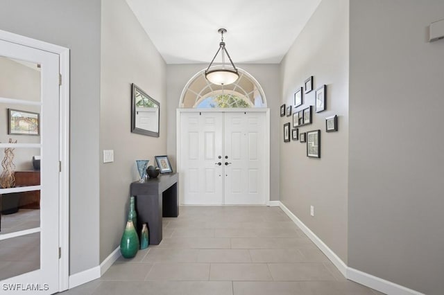 tiled foyer featuring baseboards