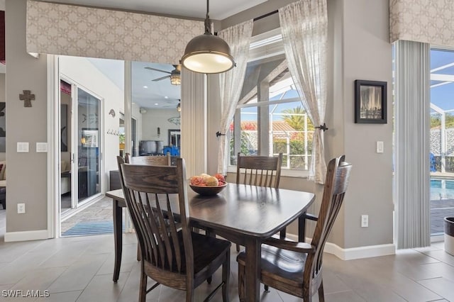 dining area with wallpapered walls, light tile patterned flooring, baseboards, and ceiling fan